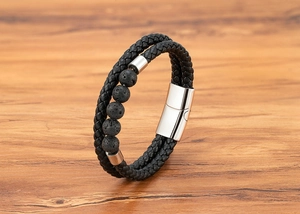 Detail of black braided leather bracelet with lava stones and silver magnetic clasp