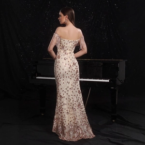 Detalle del vestido de noche con lentejuelas champán y elegantes flecos en las mangas