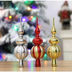 Tre puntali per albero di Natale lucidi in oro rosso e argento su superficie di legno