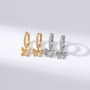 Close-up of gold and silver bow dangle earrings with sparkling diamond-set hoops