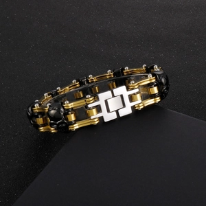 Detail view of gold-plated skull link bracelet with mechanical H-clasp on display stand