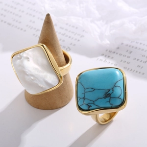 Gold square signet ring with white shell and turquoise inlay for women on wooden stand