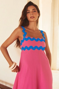 Detail of blue ric-rac trim on vibrant pink linen maxi dress with delicate straps