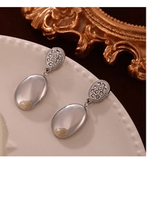 Detailed macro view of vintage silver-tone oval drop earrings with shimmering rhinestones