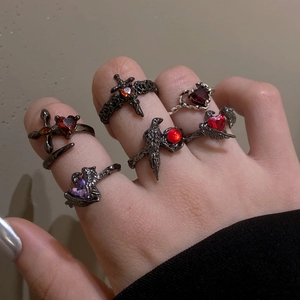 Gothic punk ring set featuring black crow, red heart crystals, and silver crosses
