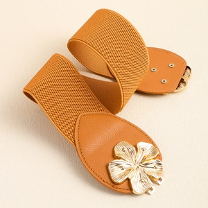 Close-up of brown elastic waist belt with large golden metal flower buckle detail