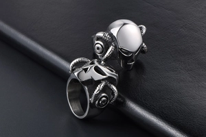 Macro detail of the silver mechanical ram horn skull ring on black leather surface