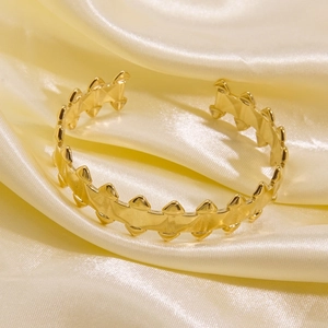 Detailed close-up of 14K gold-plated titanium steel cuff bracelet with spiky serrated edges