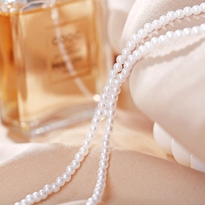 Detailed macro view of triple-layered baroque pearl necklace with high-luster cream pearls