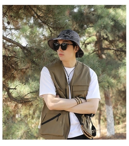 Close-up of olive green outdoor utility vest with multi-pocket design for fishing