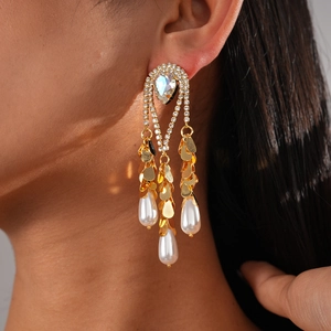 Détail de longues boucles d'oreilles frangées plaquées or 18k avec perles et cristaux