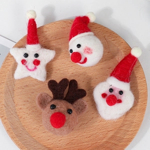 Handmade felt Christmas ornaments featuring Santa, snowman, and reindeer on a wooden tray