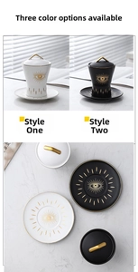Macro detail of Evil Eye ceramic coffee cup and saucer with gold trim on marble surface