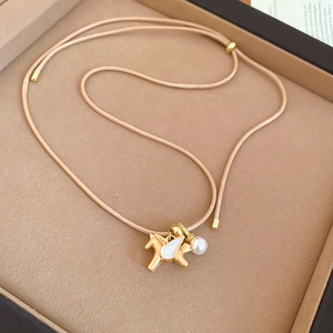 Détail du pendentif cheval avec ailes blanches et perle sur cordon tressé crème