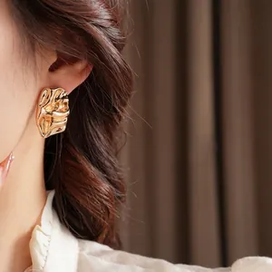 Irregular gold lava textured stud earrings with a modern molten metal aesthetic