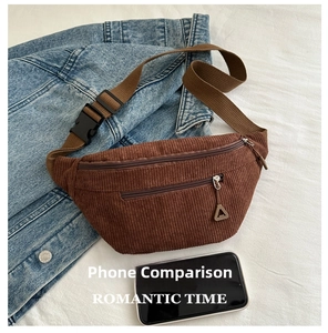 Detailed macro view of brown corduroy waist bag showing dual zippers and texture