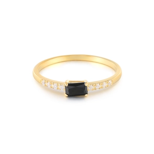 Detail of gold ring with rectangular black gemstone and small side zirconias
