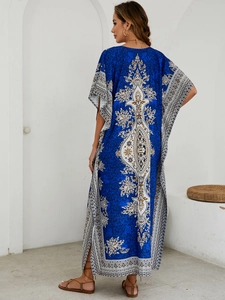 Detail of royal blue bohemian kaftan featuring ethnic patterns and side slit design