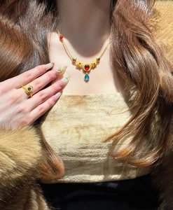Detail view of ethnic style round necklace with red stone and blue gemstone inlay