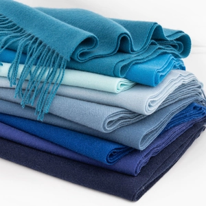 Dettaglio di sciarpe blu sfumate effetto cashmere con nappe e texture molto soffice