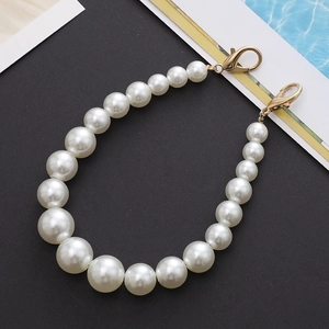 Detail of gradient white pearl strap with gold lobster clasps for phones and bags