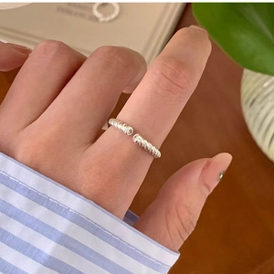 Detailed view of silver twisted rope open ring with adjustable band on model's hand
