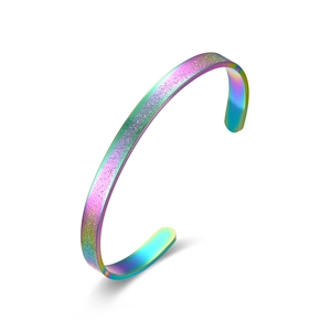 Detalle macro de brazalete de acero de titanio irisado con acabado de purpurina