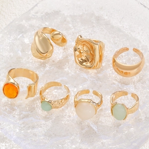 Close-up of vintage gold stacking rings with hammered texture and colorful gemstones