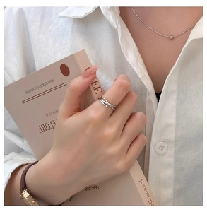Detail of zircon star ring on model holding a book in soft natural light