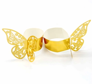 Detail of two gold laser-cut butterfly napkin rings with intricate hollow patterns