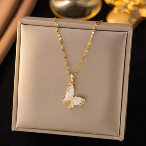 Elegant butterfly pendant necklace with zircon inlays and golden chain on a jewelry box