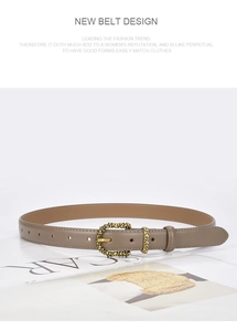 Detail of vintage textured metal buckle on a brown leather belt over a magazine