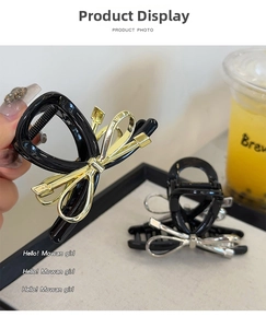 Detail of sleek black butterfly hair claw with metallic gold and silver accents