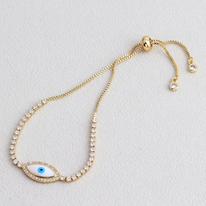 Close-up of golden evil eye sliding bracelet with micro-paved cubic zirconia stones