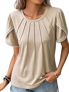 Close-up of pleated round neck detail and white lace trim on beige short sleeve t-shirt
