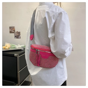 Close-up of pink crossbody bag with silver rhinestones and wavy pattern wide strap