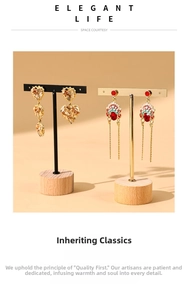 Detail of metal earring display stand featuring wooden base with tassel and heart earrings