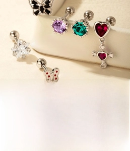 Detail of silver titanium steel piercing set with butterfly, star, and zircon studs