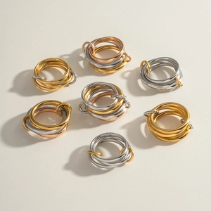 Macro view of interlocking stainless steel bands in gold, silver, and rose gold finish