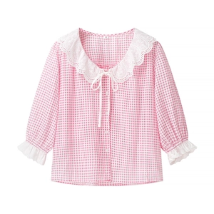 Detail of pink plaid shirt featuring white lace collar and sweet bow tie fastener
