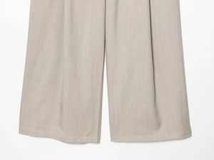 Detailed macro view of beige grey trousers hem with high-quality stitching and woven texture