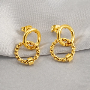 Detail of interlocking gold hoop earrings with twisted texture and square accents