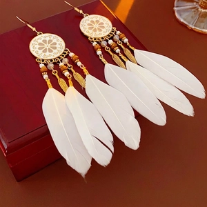 Boucles d'oreilles bohèmes avec plaques dorées et longues plumes blanches soyeuses