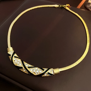 Detailansicht der goldenen Schlangenkette mit schwarzer Emaille und funkelnden Strasssteinen