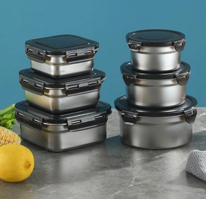 6-piece stainless steel food container set with black airtight lids on marble surface