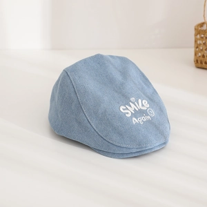 Detail of blue denim beret with white SMILE Again embroidery and clean stitching