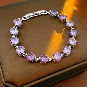 Detailed macro view of a purple zircon bracelet with round gemstones on a jewelry box