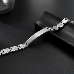 Close-up of polished silver stainless steel hip hop bracelet with smooth curved plaque