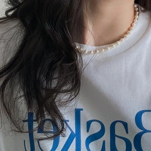 Elegant single-layer pearl necklace shown on a model neck with round white pearls