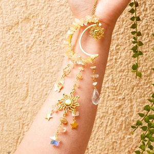 Detail of golden moon suncatcher featuring yellow crystal stones and glass teardrop